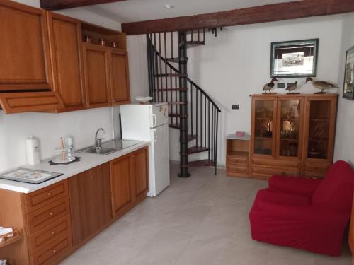 una cucina con armadi in legno e un divano rosso di IL GRANCHIO BLU a Comacchio