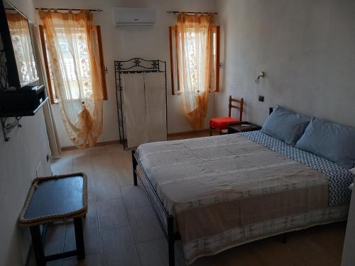una camera con letto, sedia e finestre di IL GRANCHIO BLU a Comacchio