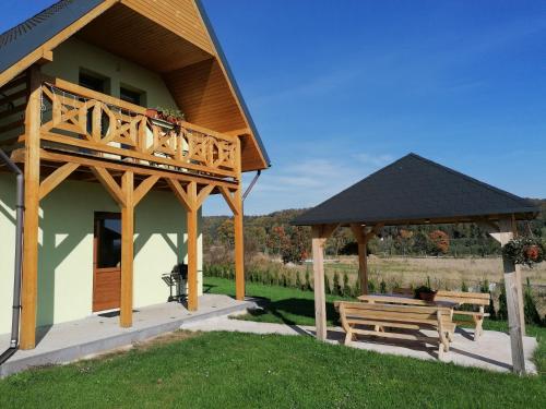 ein Haus mit zwei Bänken und einem Pavillon in der Unterkunft Domki pod Derkaczem in Radków