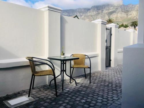 a table and chairs on a patio with a view of mountains at 18 on Faure in Cape Town