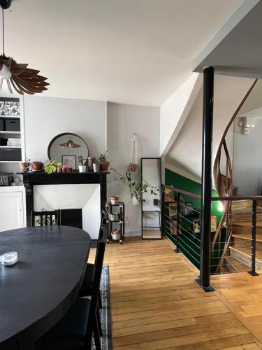 een woonkamer met een tafel en een eetkamer bij Duplex de charme en centre ville avec terrasse in Brive-la-Gaillarde