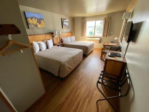 a hotel room with two beds and a table with a chalkboard at Rocker Inn in Butte