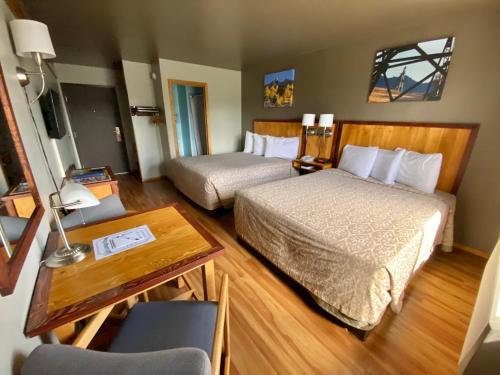 a hotel room with two beds and a table and a desk at Rocker Inn in Butte