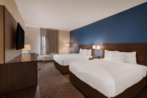 a hotel room with two beds and a flat screen tv at La Quinta Inn & Suites by Wyndham Sulphur Lake Charles in Sulphur