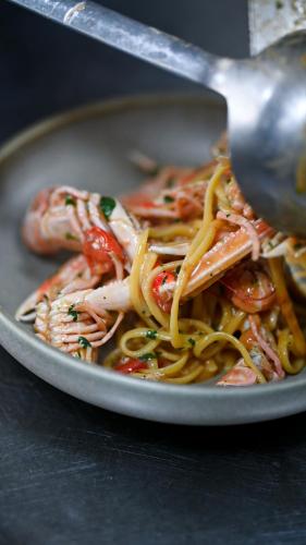 a plate of food with shrimp and noodles with a spoon at Royal G Max in Golem