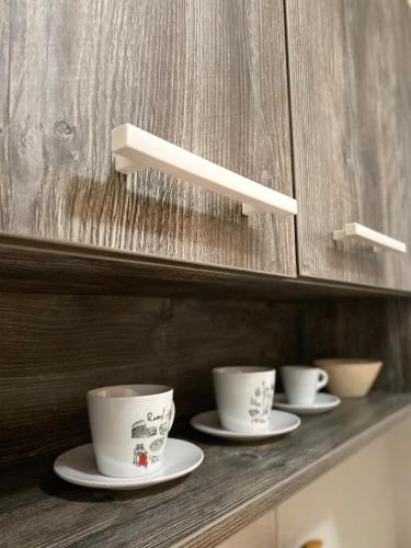 three cups and saucers sitting on a shelf at Family Home Niš , FREE parking in Niš
