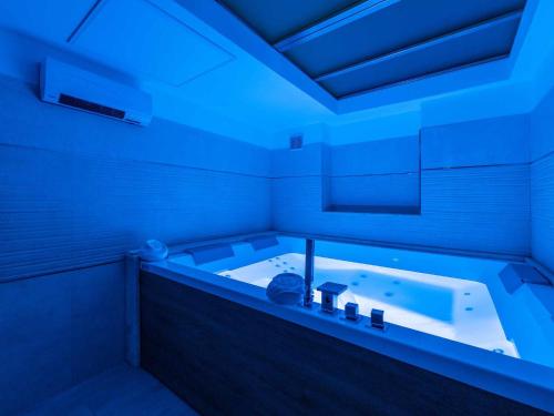 ein Badezimmer mit einer Badewanne mit blauem Licht in der Unterkunft Karalis Relais Appartamento privato con Jacuzzi in Cagliari