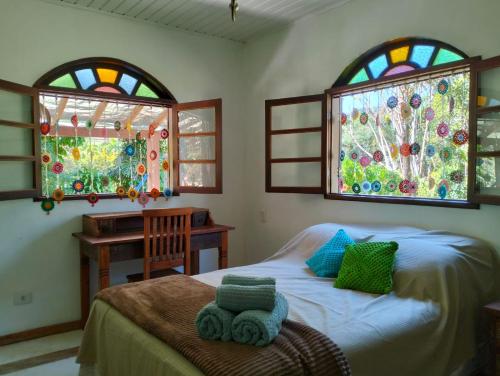 ein Schlafzimmer mit einem Bett und zwei Buntglasfenstern in der Unterkunft Casa da Baronesa in Santa Maria Madalena