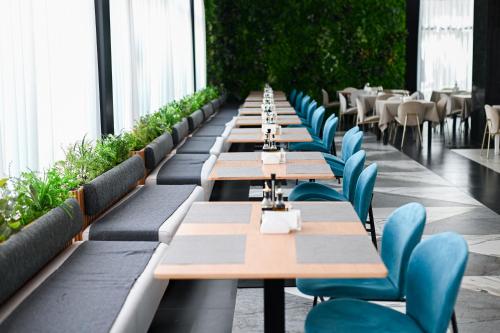 a row of tables and chairs in a restaurant at Royal G Max in Golem