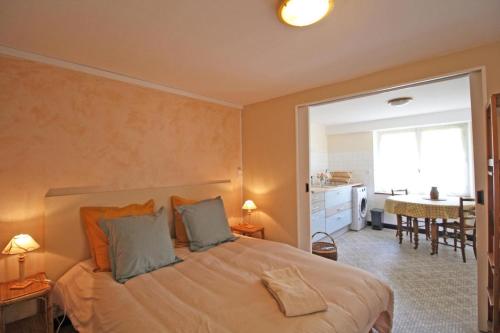 a bedroom with a bed and a dining room at Les vieux fourneaux in Nantiat