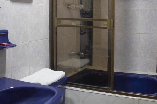 a bathroom with a shower and a blue sink at Ayenda Marana in Manizales