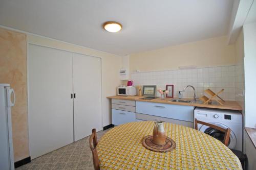 a kitchen with a table and a sink and a stove at Les vieux fourneaux in Nantiat