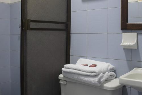a bathroom with towels on top of a toilet at Ayenda Marana in Manizales