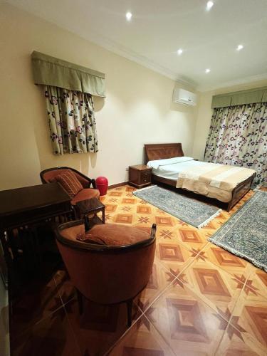 um quarto com uma cama e duas cadeiras em قصر علي لسان الوزراء مارينا العلمين مطروح em El Alamein