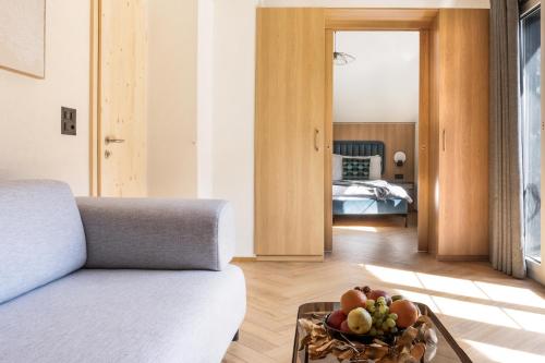 a living room with a couch and a bowl of fruit on a table at Chalet Casita in Engelberg