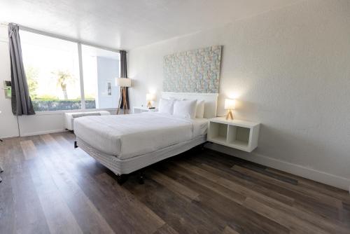 a bedroom with a white bed and a large window at Oneway Savannah in Savannah