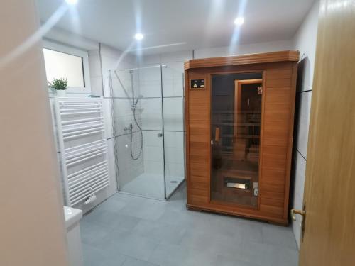 baño con ducha a ras de suelo y puerta de madera en Appartement Sonnenrot, en Sankt Lorenzen ob Murau