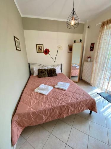 a bedroom with a pink bed with two towels on it at DeVal • Kiveri apartment • in Kiveri