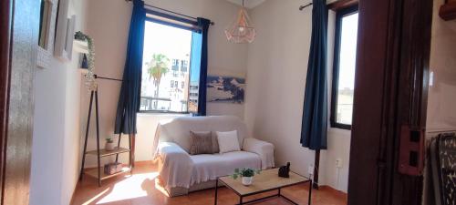 sala de estar con silla blanca y ventana en Las Palmas centro con terraza privada, en Las Palmas de Gran Canaria