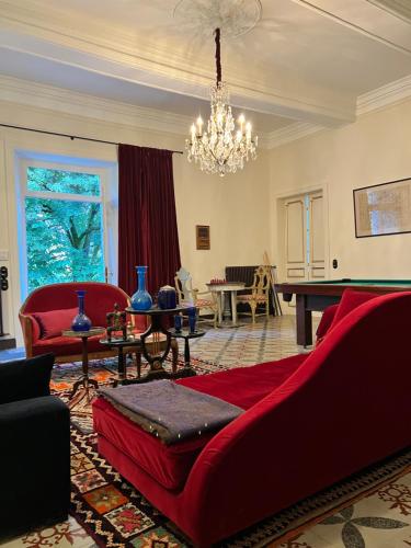 a living room with a red couch and a pool table at Château La Bruguière in Tornac