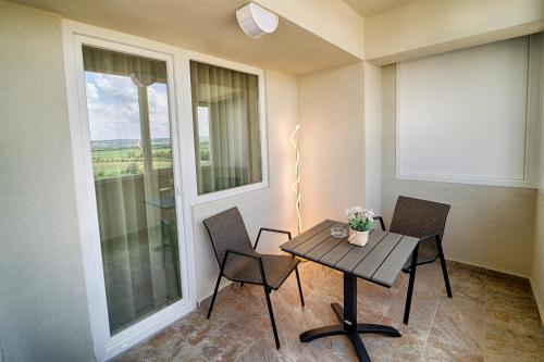 a table and chairs in a room with a window at Apartament Kenya in Bacău
