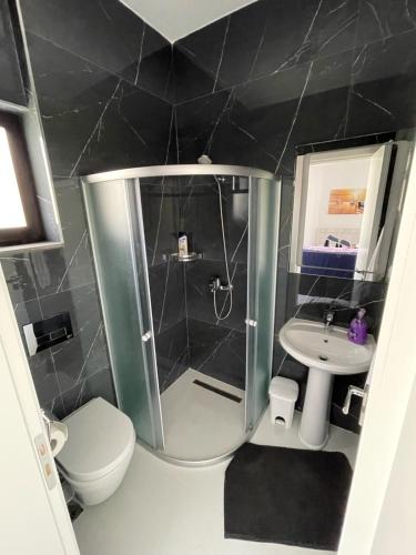 a bathroom with a shower and a toilet and a sink at Apartment Tefiti in Sarandë