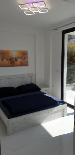 a bedroom with a bed with a painting on the wall at Apartment Tefiti in Sarandë