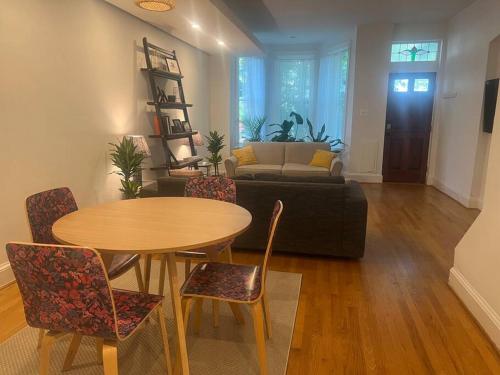 uma sala de estar com uma mesa e cadeiras e um sofá em 3-Bedroom House with Cute Patio Explore DC on Foot em Washington