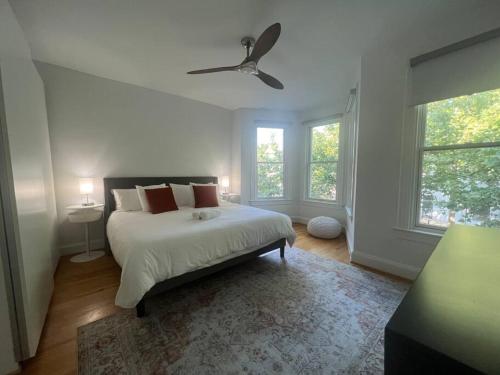 um quarto branco com uma cama e 2 janelas em 3-Bedroom House with Cute Patio Explore DC on Foot em Washington