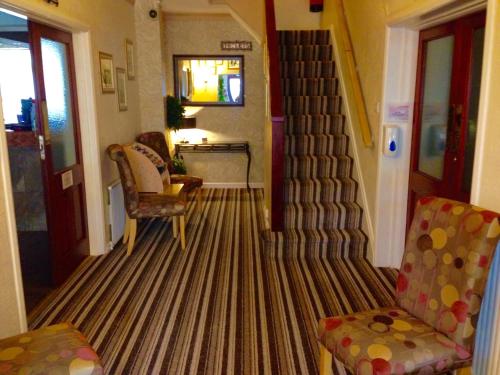 a living room with a carpeted floor with a staircase at Corona Blackpool in Blackpool