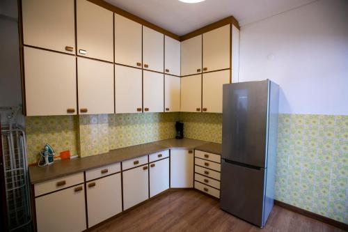 a kitchen with white cabinets and a stainless steel refrigerator at Harmony Apartment Kavala in Kavála