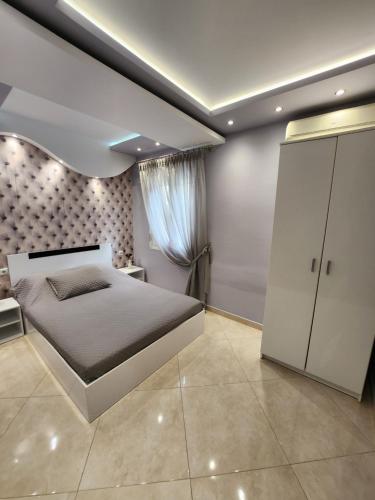 Un dormitorio con una cama grande y una ventana en Kavala Lux Apartment, en Kavala