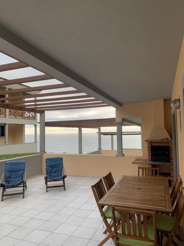 a patio with a wooden table and chairs and the ocean at Sunset House With Seaview & Terrace by Vacationy in Leiria