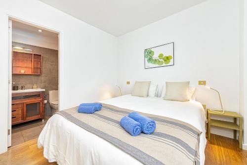 a bedroom with a large white bed with blue towels on it at Fantastic New Apartment in Salinetas. in Melenara