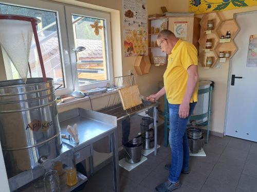 a man standing in a kitchen preparing food at Dolina Miodu - Kaszuby, Sauna, Gorąca Balia in Borowina