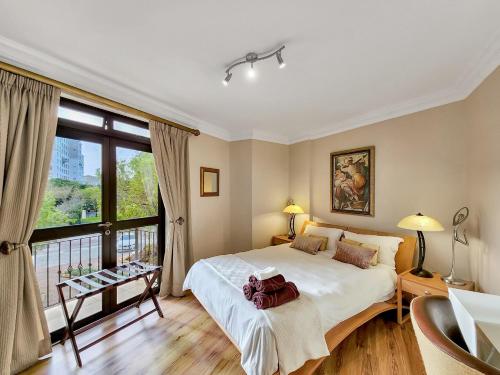 ein Schlafzimmer mit einem großen Bett und einem großen Fenster in der Unterkunft Family-Friendly Home with Ample Space in Kapstadt