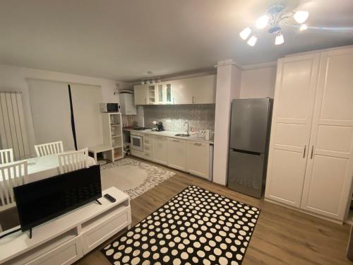 ママイア・ノルドにあるFamily Time Apartment Mamaia Nordのキッチン(白いキャビネット、ステンレス製の冷蔵庫付)