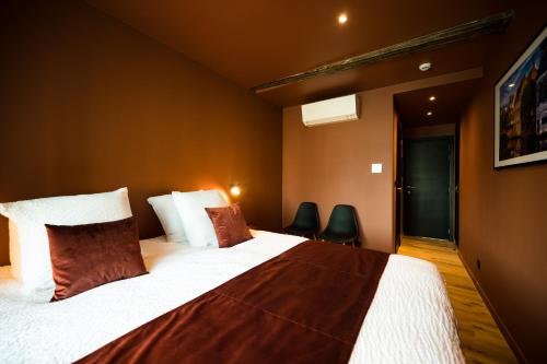 - une chambre avec un grand lit et deux chaises dans l'établissement Guest House La Civière d'or, à Bruges