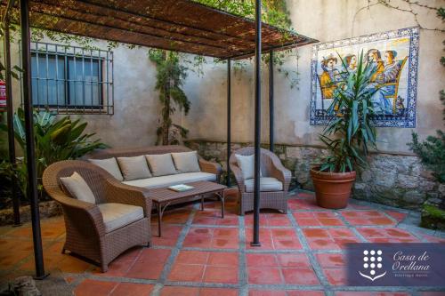 un patio con sillas, un sofá y una sombrilla en Hotel Boutique Casa de Orellana, en Trujillo