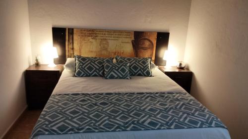 Mi habitación de invitados في بويرتو ديل روزاريو: غرفة نوم بسرير كبير مع مواقف ليلتين