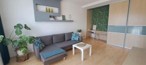 - un salon avec un canapé et une table dans l'établissement Zaspa Apartament, à Gdańsk