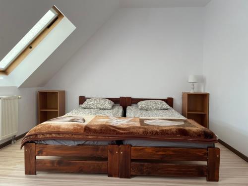1 dormitorio con cama de madera en el ático en Bursztynek, en Hel
