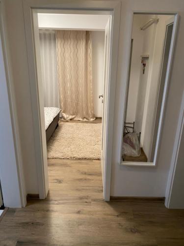 ママイア・ノルドにあるFamily Time Apartment Mamaia Nordの鏡付きのベッドルームへの開放ドア