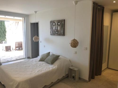 a bedroom with a bed with a picture on the wall at A casa dolce in Le Castellet