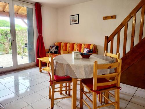 une salle à manger avec une table, des chaises et un canapé dans l'établissement Gîte VILLA 34 Résidence Le Grand Bleu, à Vendres
