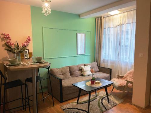 een woonkamer met een bank en een tafel bij M2 Suite by Central Park in Kragujevac