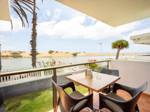 a table and chairs on a balcony with a view of the water at Apartamento Maypa 4 Arena in Meloneras