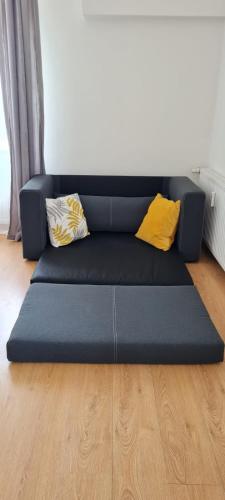 a blue couch with two pillows on a wooden floor at TOP 06 in Fohnsdorf