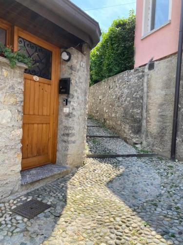 a wooden door on a building with a stone wall at Al Cottage in Oliveto Lario