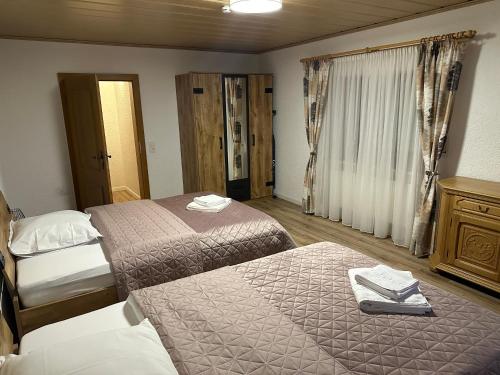 a hotel room with two beds and a window at Haus Monica in Bodenmais